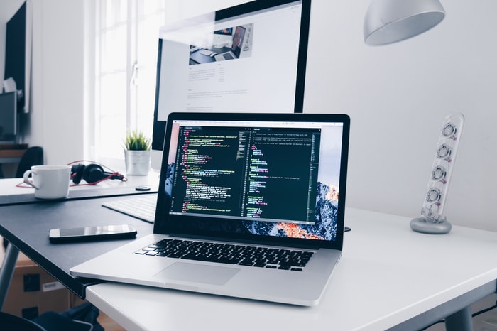 Software development workspace with source code displayed on a laptop